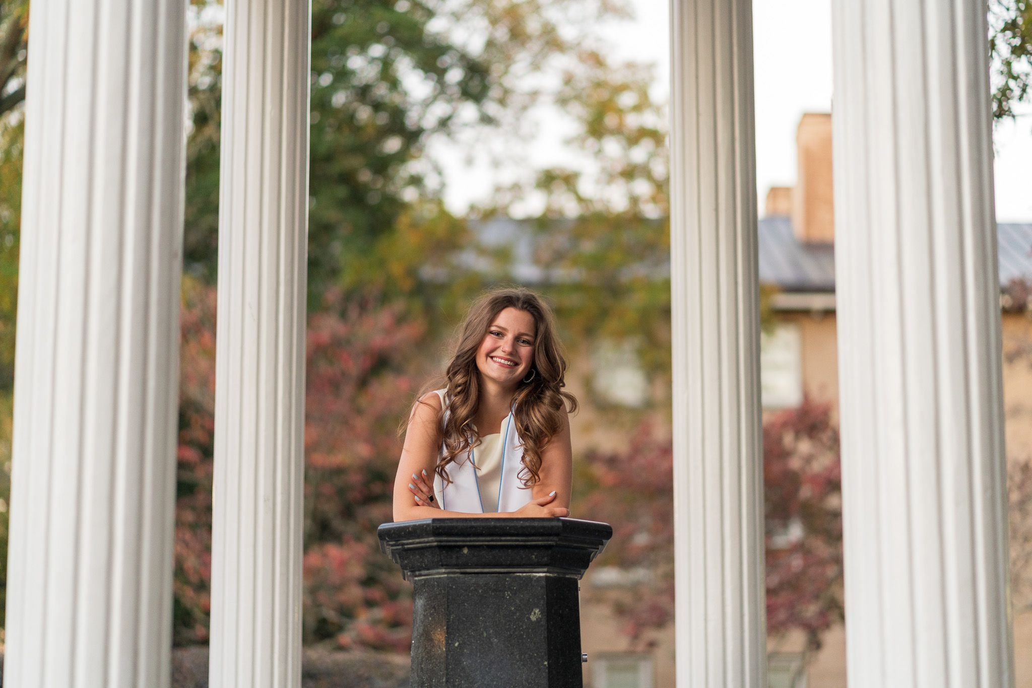 A grad at the Old Well leaning into the camera
